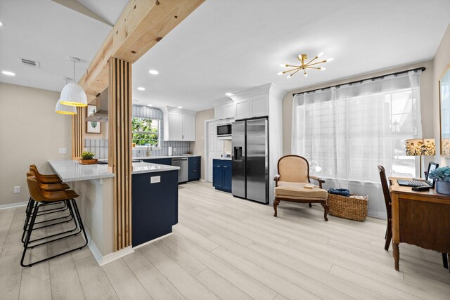 112 Meigs Dr, Shalimar, FL 32579 - kitchen featuring stainless steel appliances, a peninsula, light countertops, a kitchen breakfast bar, and light wood finished floors