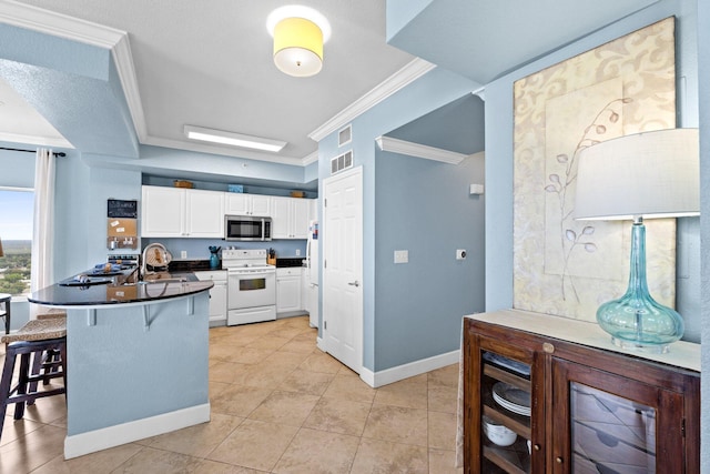 16819 Front Beach Rd Unit 2300, Panama City Beach, FL 32413 - kitchen with stainless steel microwave, white electric stove, dark countertops, a kitchen bar, and white cabinetry