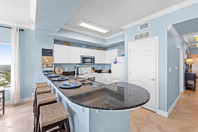 16819 Front Beach Rd Unit 2300, Panama City Beach, FL 32413 - kitchen with white appliances, ornamental molding, a breakfast bar, white cabinetry, and light tile patterned floors