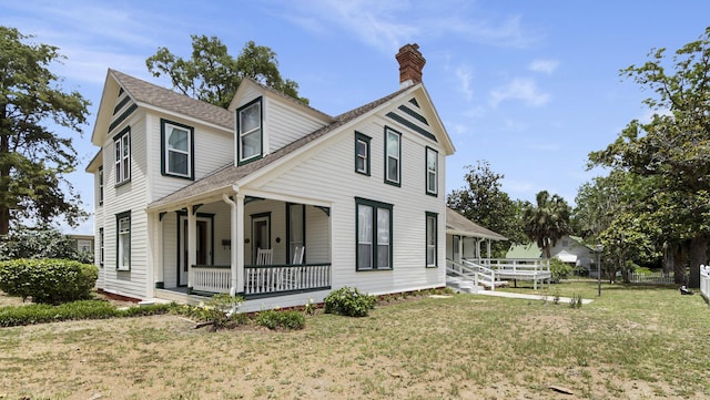 119 E Live Oak Ave, Defuniak Springs, FL 32435 - view of property exterior with covered porch, a chimney, a yard, and roof with shingles