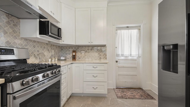 119 E Live Oak Ave, Defuniak Springs, FL 32435 - kitchen with appliances with stainless steel finishes, under cabinet range hood, light countertops, white cabinetry, and crown molding