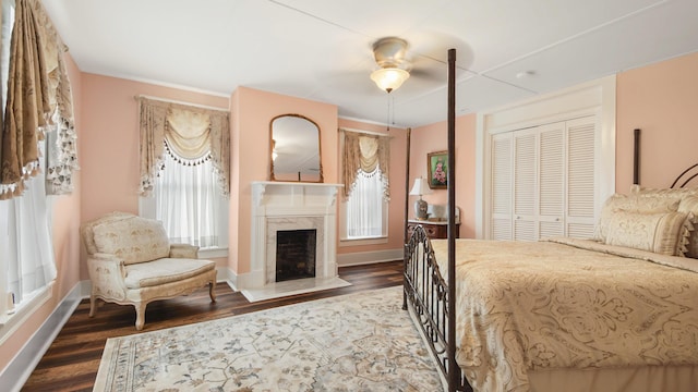 119 E Live Oak Ave, Defuniak Springs, FL 32435 - bedroom featuring dark wood-style flooring, baseboards, a fireplace, and a closet