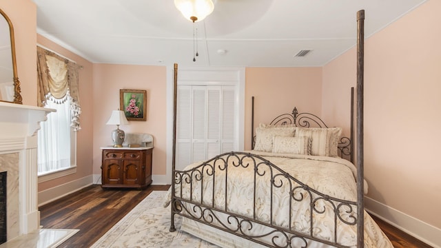 119 E Live Oak Ave, Defuniak Springs, FL 32435 - bedroom with wood finished floors, baseboards, a closet, and a fireplace