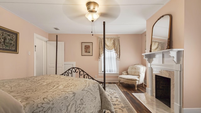 119 E Live Oak Ave, Defuniak Springs, FL 32435 - bedroom featuring dark wood-type flooring, a high end fireplace, baseboards, and ceiling fan