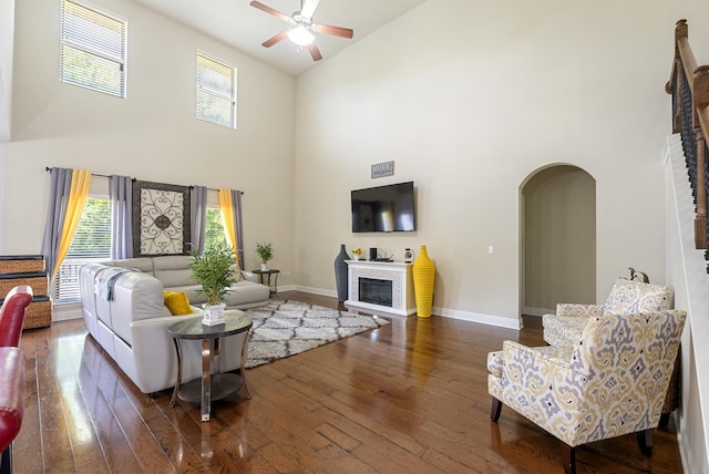 170 Windchime Way, Freeport, FL 32439 - living room with high vaulted ceiling, ceiling fan, arched walkways, a glass covered fireplace, and hardwood / wood-style floors