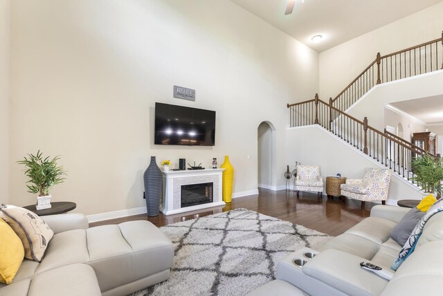 170 Windchime Way, Freeport, FL 32439 - living area featuring arched walkways, wood finished floors, a towering ceiling, baseboards, and stairs