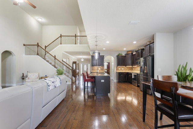 170 Windchime Way, Freeport, FL 32439 - living area featuring arched walkways, dark wood-style flooring, ceiling fan, stairway, and recessed lighting