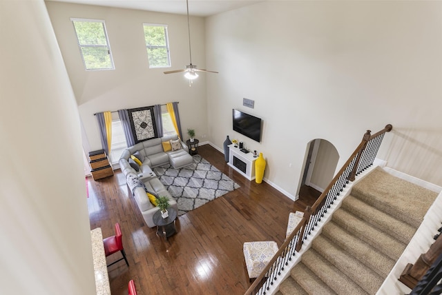 170 Windchime Way, Freeport, FL 32439 - living room with stairway, wood-type flooring, baseboards, ceiling fan, and a high ceiling