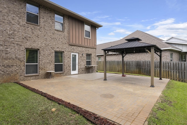 170 Windchime Way, Freeport, FL 32439 - back of property with a gazebo, board and batten siding, brick siding, a fenced backyard, and a patio