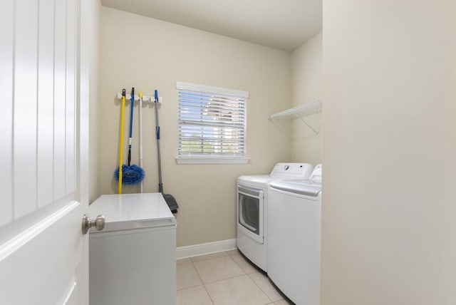 170 Windchime Way, Freeport, FL 32439 - laundry area featuring washing machine and clothes dryer, light tile patterned floors, and baseboards