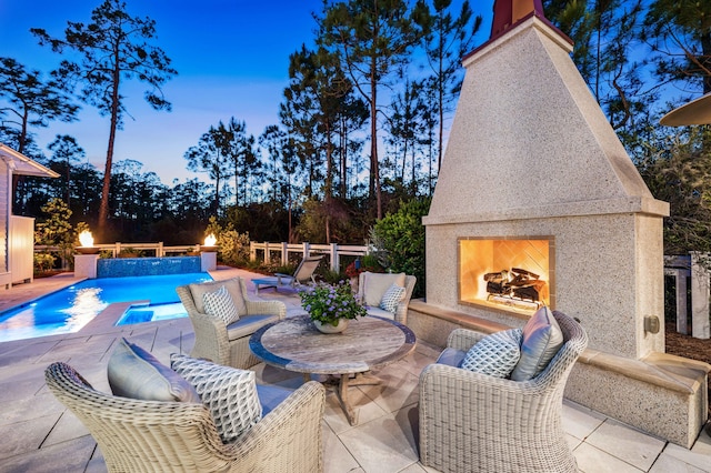 667 E Royal Fern Way, Santa Rosa Beach, FL 32459 - pool at dusk featuring a lit fireplace and a patio area