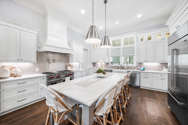 667 E Royal Fern Way, Santa Rosa Beach, FL 32459 - kitchen featuring high end appliances, ornamental molding, premium range hood, white cabinetry, and a center island