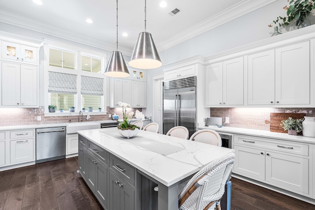 667 E Royal Fern Way, Santa Rosa Beach, FL 32459 - kitchen with stainless steel appliances, gray cabinets, crown molding, a breakfast bar, and a kitchen island
