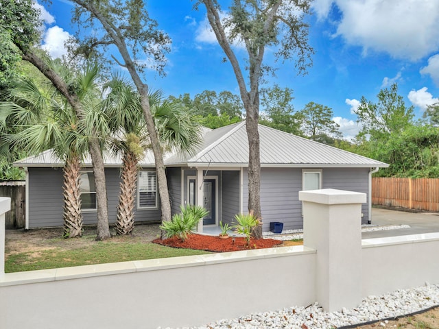 311 Beal Pkwy, Fort Walton Beach, FL 32548 - mid-century modern home featuring a fenced front yard and metal roof