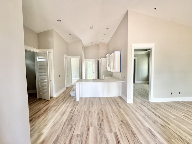 298 S 2nd St, Santa Rosa Beach, FL 32459 - kitchen with white cabinets, light countertops, light wood finished floors, baseboards, and high vaulted ceiling
