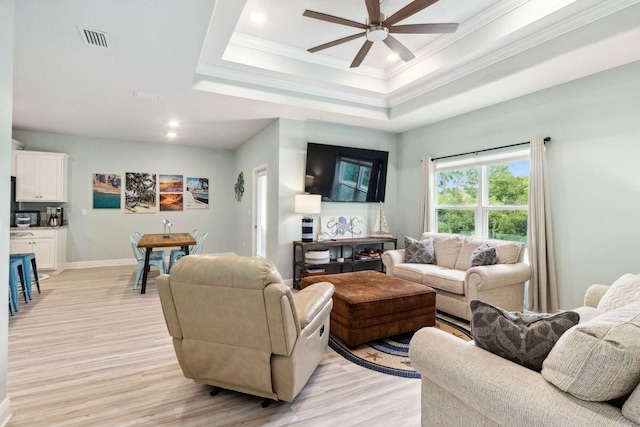 718 Backwater Rd, Port St Joe, FL 32456 - living area with ceiling fan, light wood-style floors, ornamental molding, a raised ceiling, and baseboards