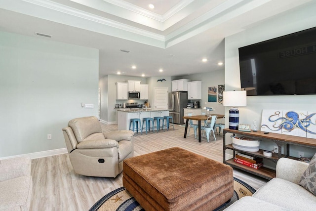 718 Backwater Rd, Port St Joe, FL 32456 - living room with crown molding, light wood-type flooring, a raised ceiling, recessed lighting, and baseboards