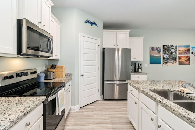 718 Backwater Rd, Port St Joe, FL 32456 - kitchen featuring appliances with stainless steel finishes, a sink, light wood-type flooring, and white cabinets