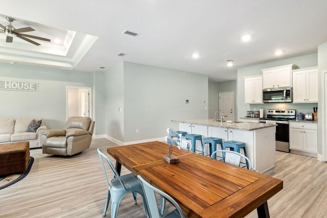 718 Backwater Rd, Port St Joe, FL 32456 - dining room with light wood-type flooring, ceiling fan, recessed lighting, baseboards, and a raised ceiling
