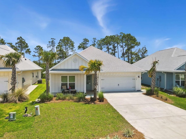 718 Backwater Rd, Port St Joe, FL 32456 - view of front of house featuring board and batten siding, a garage, concrete driveway, and a front lawn