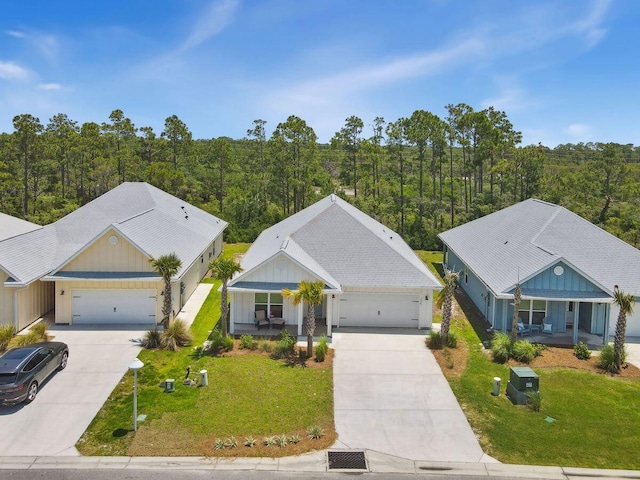 718 Backwater Rd, Port St Joe, FL 32456 - view of front of house with driveway, a porch, a front yard, and a view of trees