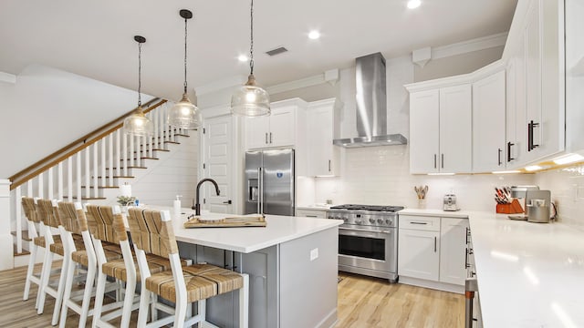51 W Okeechobee, Santa Rosa Beach, FL 32459 - kitchen featuring high quality appliances, wall chimney exhaust hood, crown molding, decorative backsplash, and light countertops