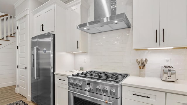 51 W Okeechobee, Santa Rosa Beach, FL 32459 - kitchen with appliances with stainless steel finishes, wall chimney exhaust hood, white cabinets, and light countertops