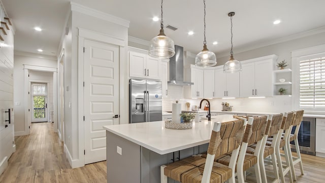 51 W Okeechobee, Santa Rosa Beach, FL 32459 - kitchen featuring high quality fridge, wall chimney exhaust hood, beverage cooler, backsplash, and white cabinetry