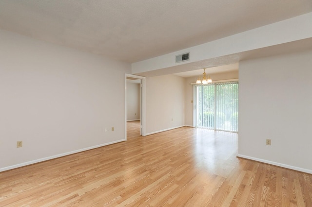 104 Country Club Dr Unit 104, Niceville, FL 32578 - empty room featuring a chandelier, light wood-style flooring, and baseboards