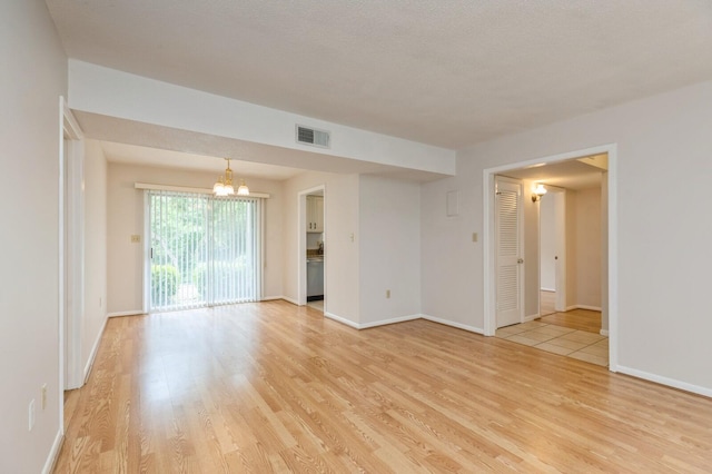 104 Country Club Dr Unit 104, Niceville, FL 32578 - unfurnished room featuring a chandelier, light wood-style floors, and baseboards