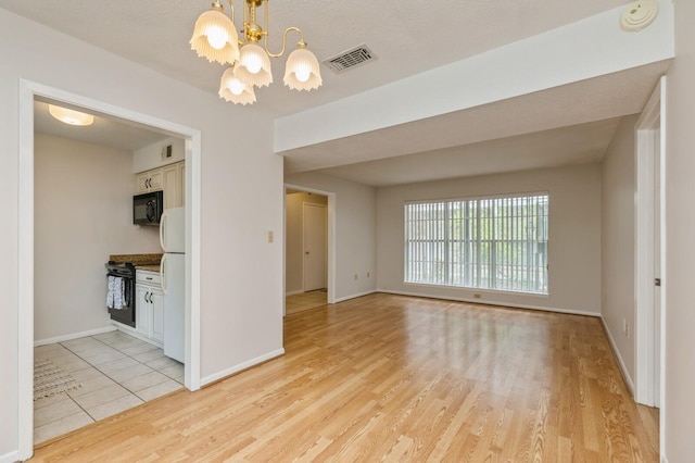 104 Country Club Dr Unit 104, Niceville, FL 32578 - spare room featuring a chandelier, light wood-style flooring, baseboards, and a smoke detector