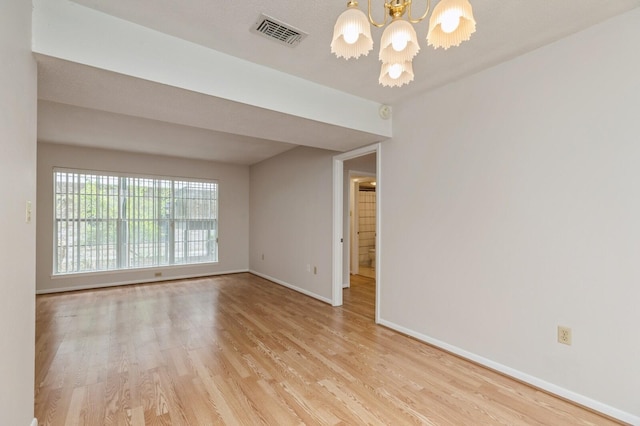 104 Country Club Dr Unit 104, Niceville, FL 32578 - spare room with a chandelier, wood finished floors, and baseboards