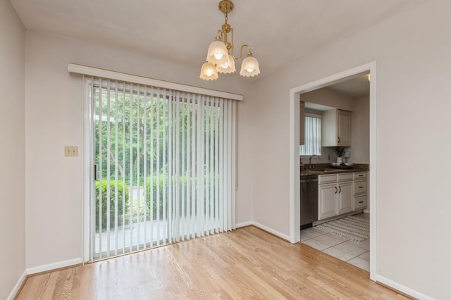 104 Country Club Dr Unit 104, Niceville, FL 32578 - unfurnished dining area with a chandelier, light wood finished floors, plenty of natural light, and baseboards