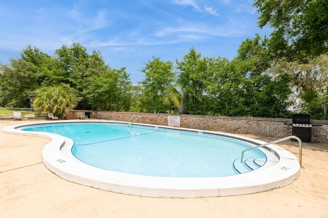 104 Country Club Dr Unit 104, Niceville, FL 32578 - community pool featuring view of wooded area, grilling area, and a patio area