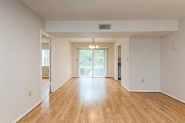 104 Country Club Dr Unit 104, Niceville, FL 32578 - empty room with a chandelier, light wood-style flooring, and baseboards