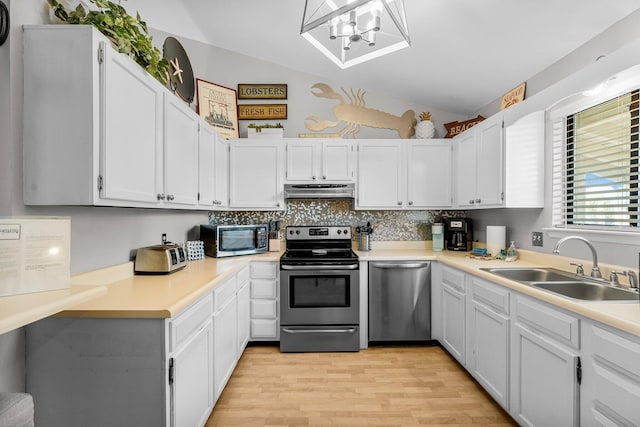 3755 Scenic Highway 98 Unit 1203, Destin, FL 32541 - kitchen featuring stainless steel appliances, a sink, light wood-style floors, lofted ceiling, and a chandelier