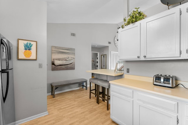 3755 Scenic Highway 98 Unit 1203, Destin, FL 32541 - kitchen featuring freestanding refrigerator, light wood-type flooring, white cabinets, light countertops, and vaulted ceiling