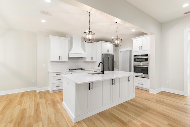 335 J Hunters Way S, Freeport, FL 32439 - kitchen with appliances with stainless steel finishes, custom exhaust hood, a sink, decorative backsplash, and an island with sink