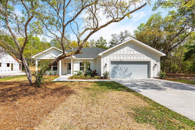 335 J Hunters Way S, Freeport, FL 32439 - view of front facade with a garage, board and batten siding, concrete driveway, and a shingled roof