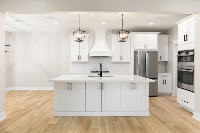 335 J Hunters Way S, Freeport, FL 32439 - kitchen featuring appliances with stainless steel finishes, premium range hood, light wood finished floors, tasteful backsplash, and recessed lighting