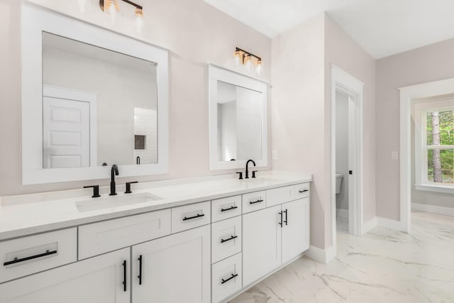 335 J Hunters Way S, Freeport, FL 32439 - bathroom featuring double vanity, baseboards, marble finish flooring, and toilet
