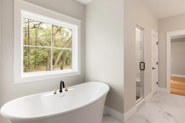 335 J Hunters Way S, Freeport, FL 32439 - bathroom with marble finish floors, baseboards, a freestanding tub, and a shower stall