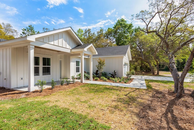 335 J Hunters Way S, Freeport, FL 32439 - view of front of house featuring board and batten siding, roof with shingles, a garage, and a front yard