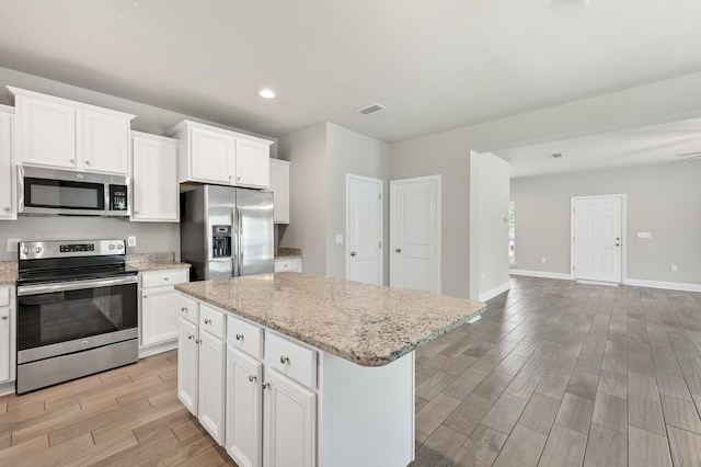 74 Tranquility Ln, Santa Rosa Beach, FL 32459 - kitchen with appliances with stainless steel finishes, light wood-style flooring, open floor plan, a kitchen island, and recessed lighting