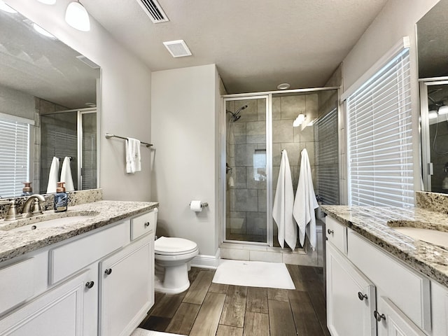 74 Tranquility Ln, Santa Rosa Beach, FL 32459 - bathroom featuring two vanities, wood finished floors, and a stall shower