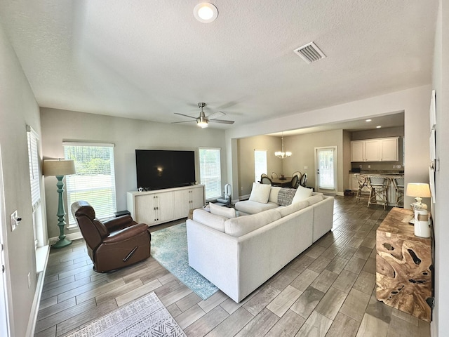 74 Tranquility Ln, Santa Rosa Beach, FL 32459 - living room with wood finish floors, a textured ceiling, ceiling fan, and a chandelier