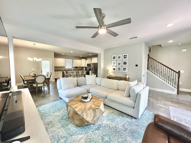 74 Tranquility Ln, Santa Rosa Beach, FL 32459 - living room with light wood-type flooring, a ceiling fan, stairs, a chandelier, and recessed lighting