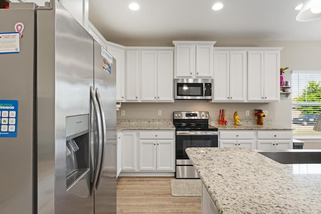 809 Whispering Creek Ave, Freeport, FL 32439 - kitchen with stainless steel appliances, white cabinets, light wood-style floors, recessed lighting, and light stone counters