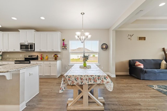 809 Whispering Creek Ave, Freeport, FL 32439 - kitchen with appliances with stainless steel finishes, light wood finished floors, a chandelier, white cabinetry, and light stone counters