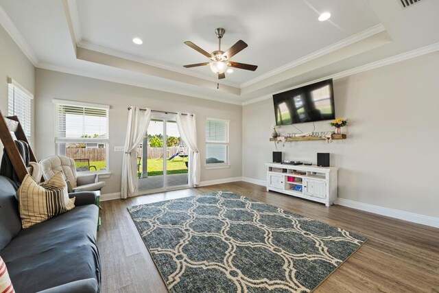 809 Whispering Creek Ave, Freeport, FL 32439 - living room featuring a raised ceiling, ceiling fan, crown molding, wood finished floors, and baseboards